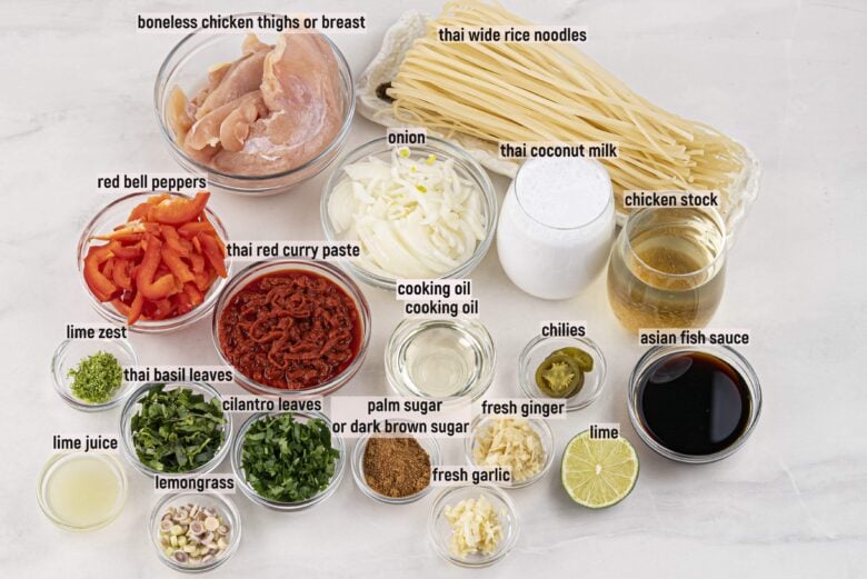 Ingredients to make Thai curry noodles on a light surface.