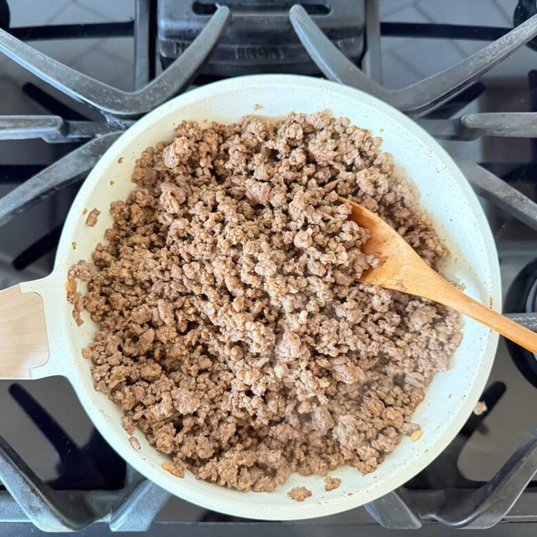Beef being cooked in a pan to make 7 layer mexican dip at home.