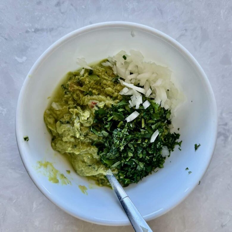 Avocado mash being made to make 7 layer mexican dip.