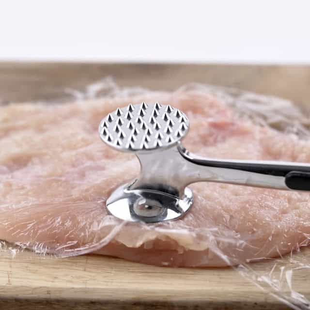 Chicken being pounded to make chicken florentine pasta.