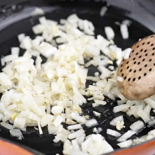 Onions and garlic being sauteed to make chicken florentine pasta.