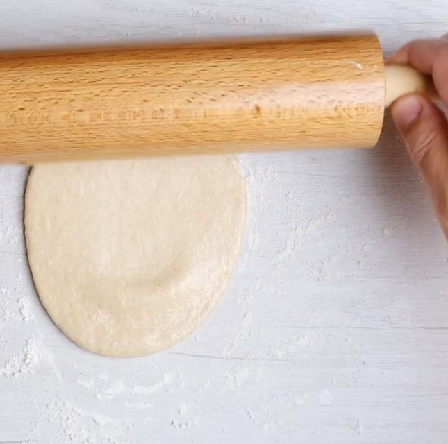 Garlic naan being rolled out.