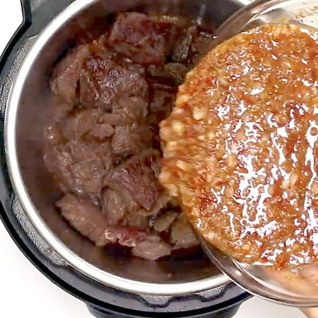 Sauce being added to sauteed beef in instant pot.