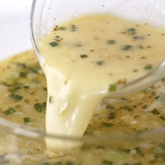 Egg mixture being poured back into lemon chicken soup.
