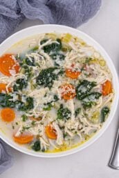 lemon chicken soup in a bowl with spoon on the side.