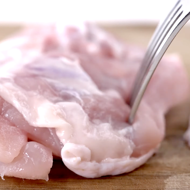 Chicken being prepped to make sheet pan chicken and potatoes.