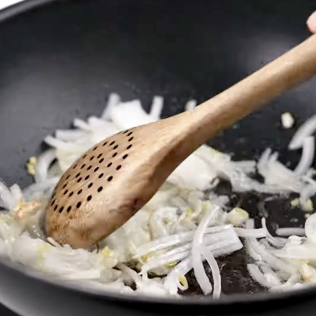 Aromatics being sauteed to make Thai curry noodles.