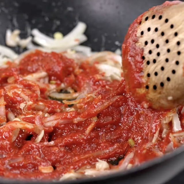 Curry paste being added to make thai curry noodles.