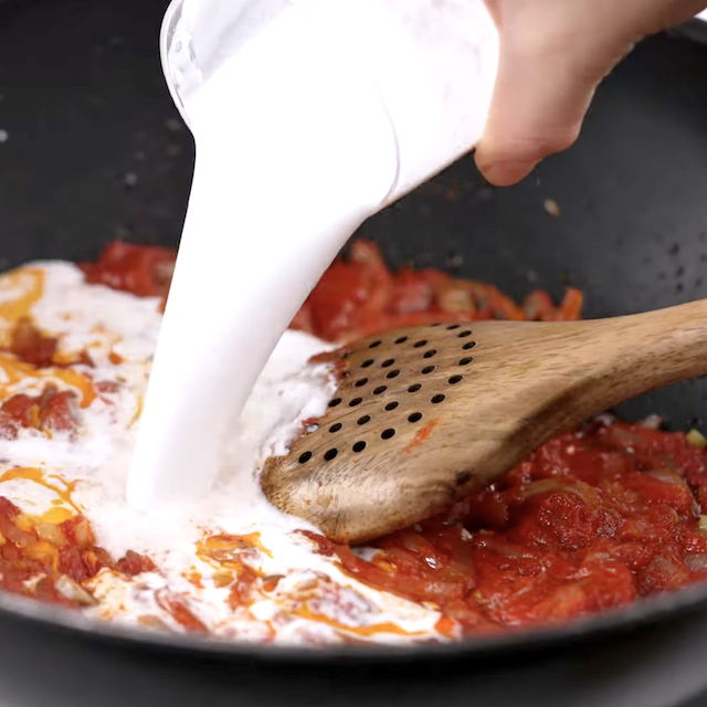 Coconut milk being poured into a pan.