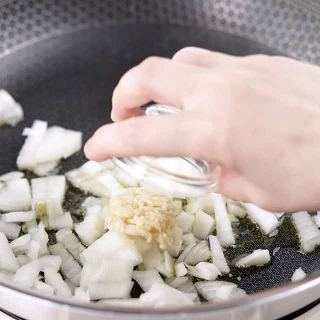 Onions and garlic being sauteed to make gnocchi with sausage.