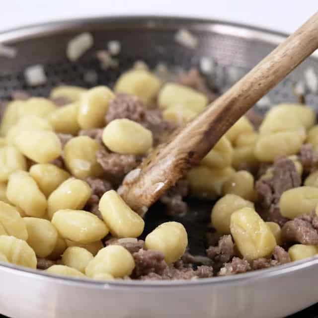 Gnocchi being cooked to make gnocchi with sausage at home.