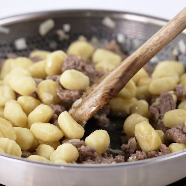 Gnocchi being cooked to make gnocchi with sausage at home.