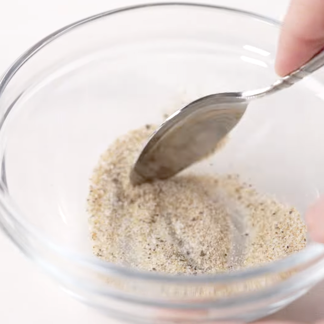 Seasoning to make lemon chicken orzo being mixed in a bowl.