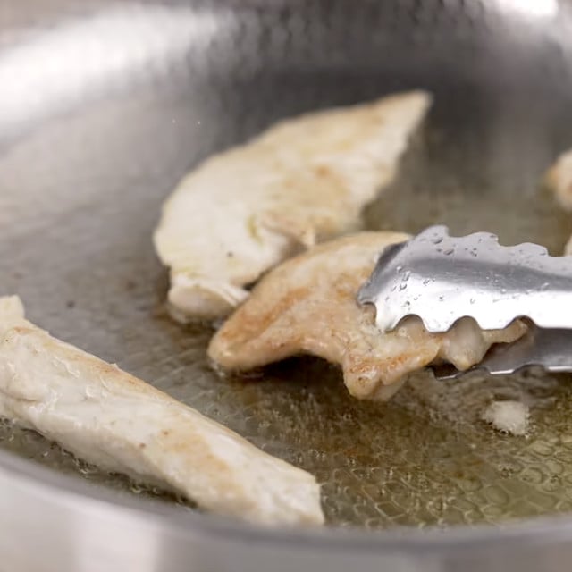 Chicken being cooked in a pan.