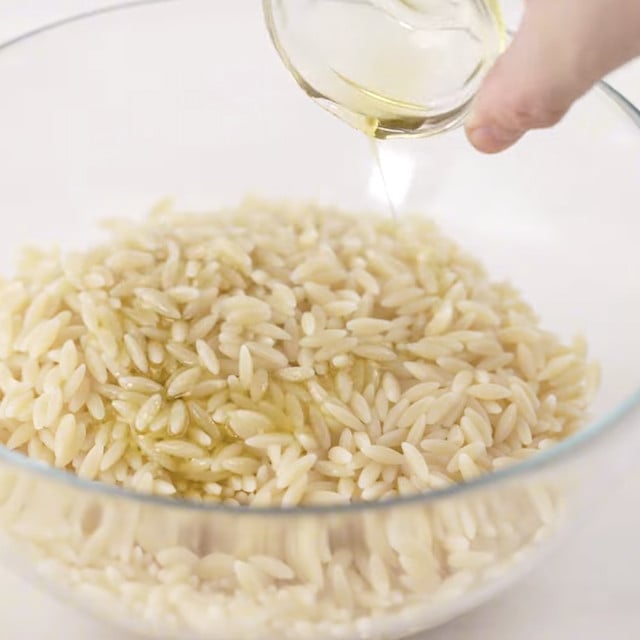 Olive oil being added to orzo.