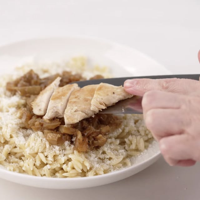 Lemon chicken orzo being layered to serve.