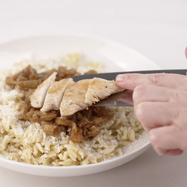 Lemon chicken orzo being layered to serve.