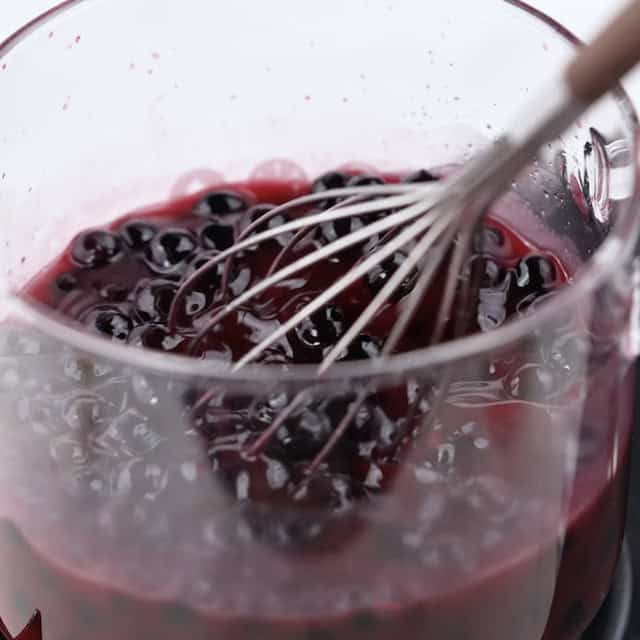 Blueberry sauce being cooked in a pot.