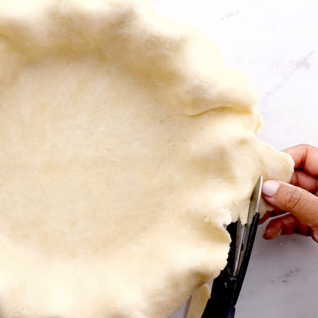 Pie crust being trimmed.