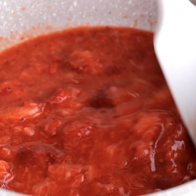 Fresh strawberry pie filling being cooked in a pan.