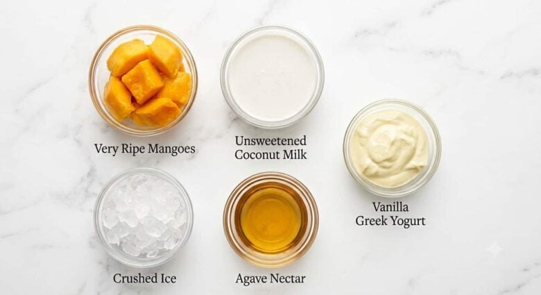 Mango, coconut milk, agave nectar, Greek yogurt, and ice in small bowls as the main ingredients needed to make this homemade smoothie recipe.
