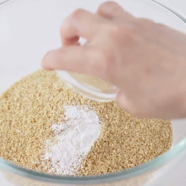 Sugars being added to a bowl to make smores bars.