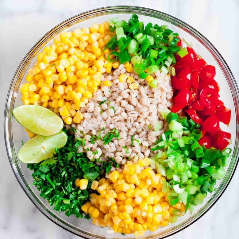 Adding all the Barley Salad ingredients into a clear glass bowl.