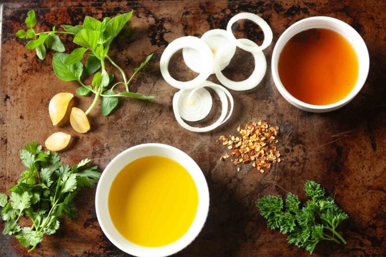 Ingredients in small white bowls that are needed to make homemade chimichurri sauce.  