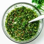 Mixing together all the ingredients in a clear glass bowl with a spoon, ready to serve or store until later.