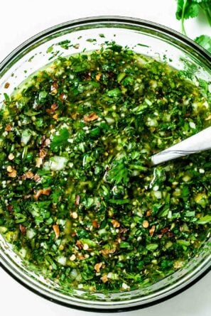 Mixing together all the ingredients in a clear glass bowl with a spoon, ready to serve or store until later.