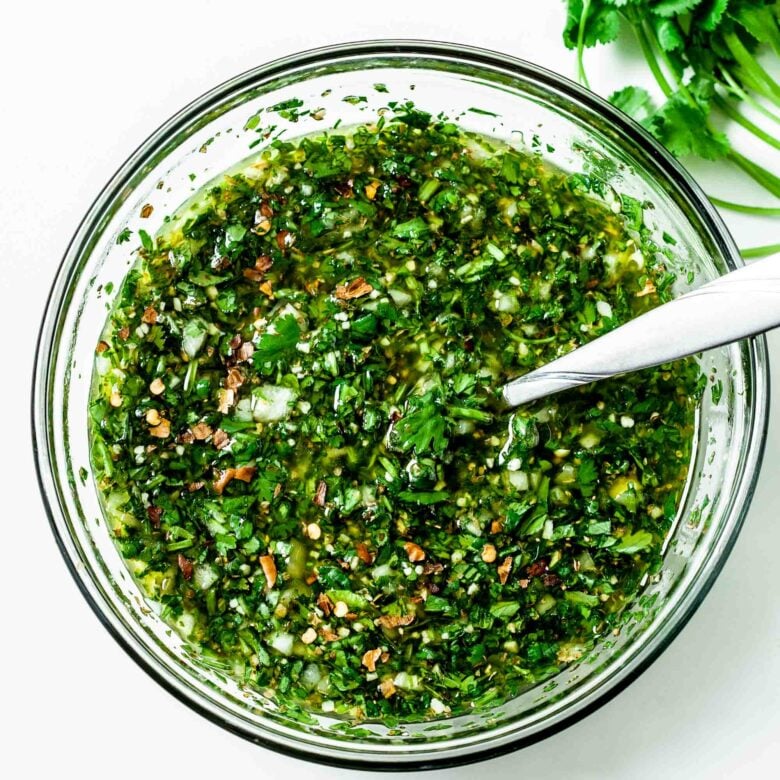 Mixing together all the ingredients in a clear glass bowl with a spoon, ready to serve or store until later. 