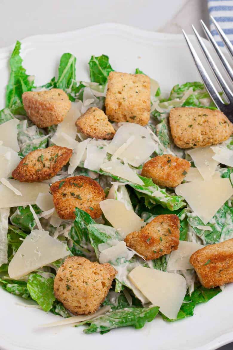 Close up of Caesar salad with the cream dressing on top and added croutons.