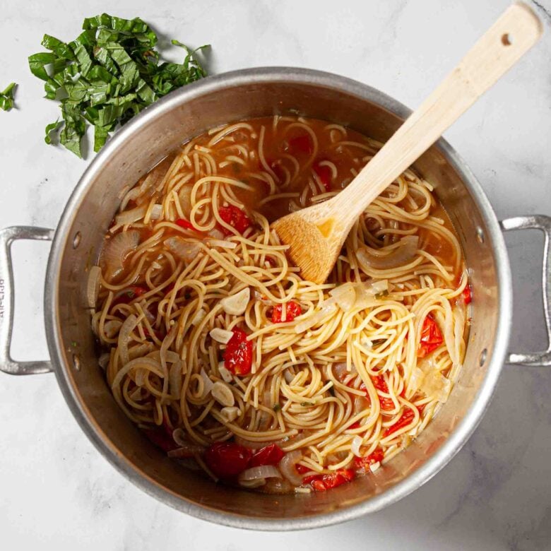 Cooking all the ingredients in the pot until the pasta is soft.