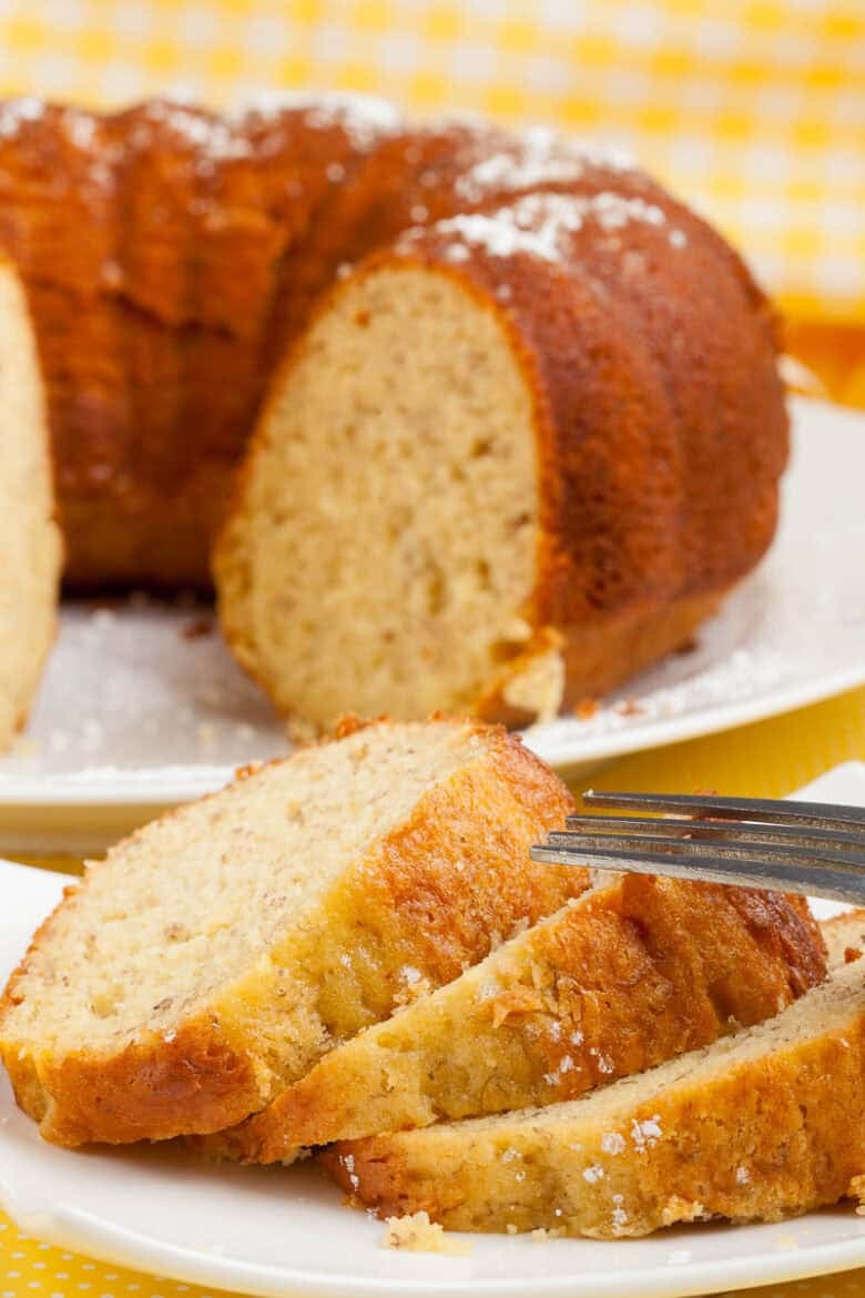 Banana pudding bundt cake sliced on a white plate.