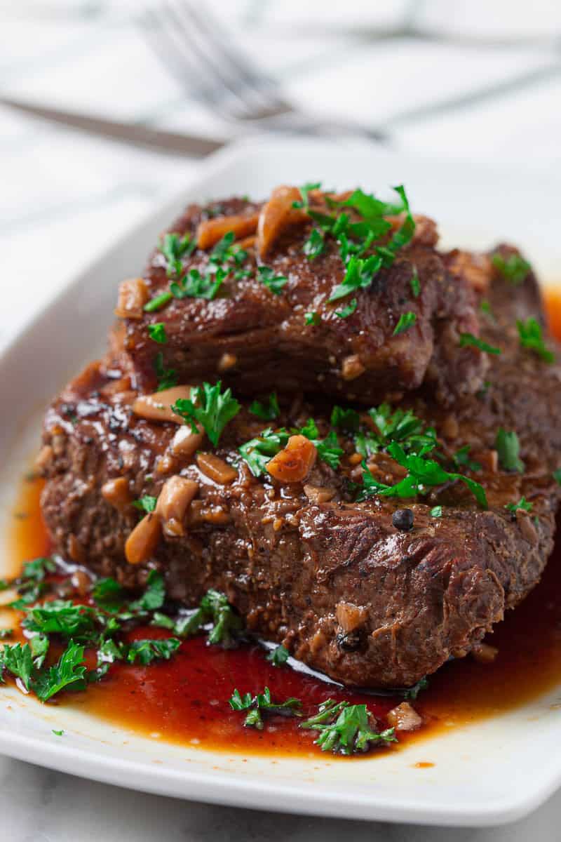 Picture of Easy Crock Pot Brisket on a white serving plate.