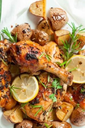 Serving plate full of Greek chicken and potatoes.