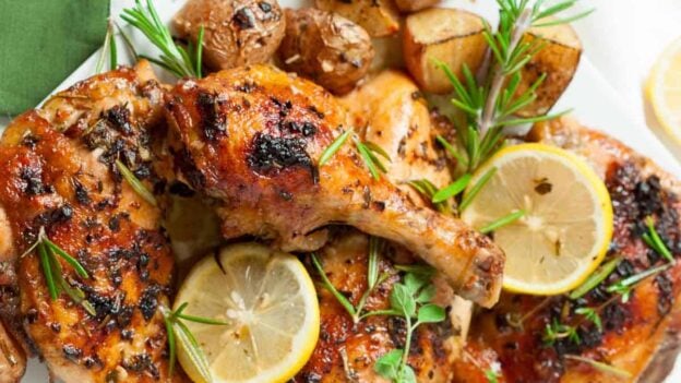 Serving plate full of Greek chicken and potatoes.
