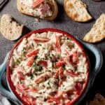 imitation crab dip in a bowl with sliced bread around it.