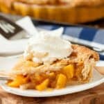 Peach pie slice with ice cream on top.