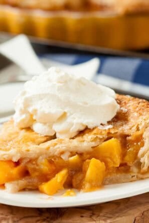 Peach pie slice with ice cream on top.