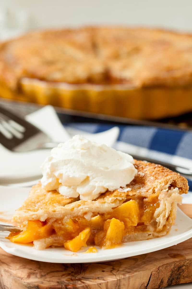 Peach pie slice with ice cream on top. 
