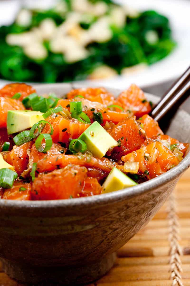 Close up of brown bowl full of salmon and veggies to make a delicious salmon poke bowl.