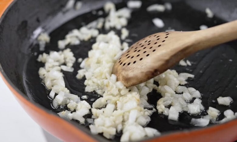Cooking the diced garlic and onions in a skillet.