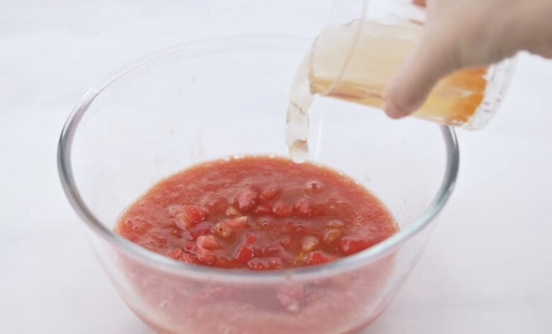 Adding the broth to the tomato and stirring.