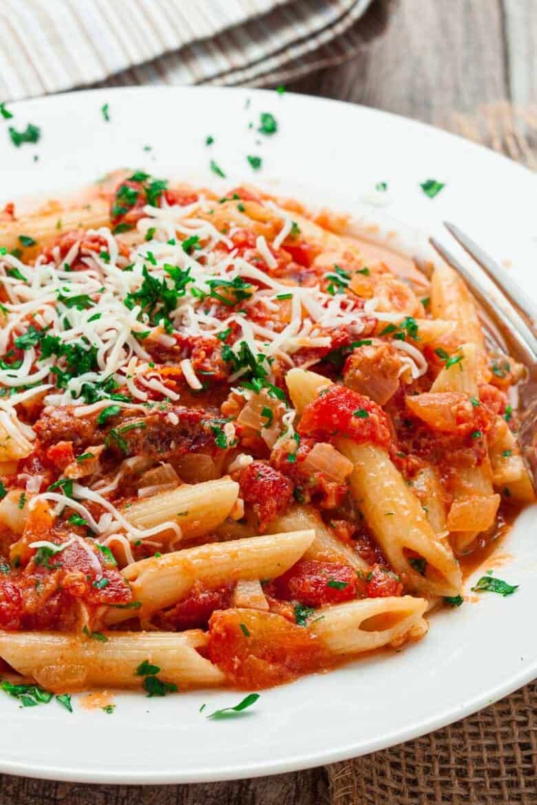 Sun Dried Tomato Pasta topped with grated cheese in a white serving bowl.