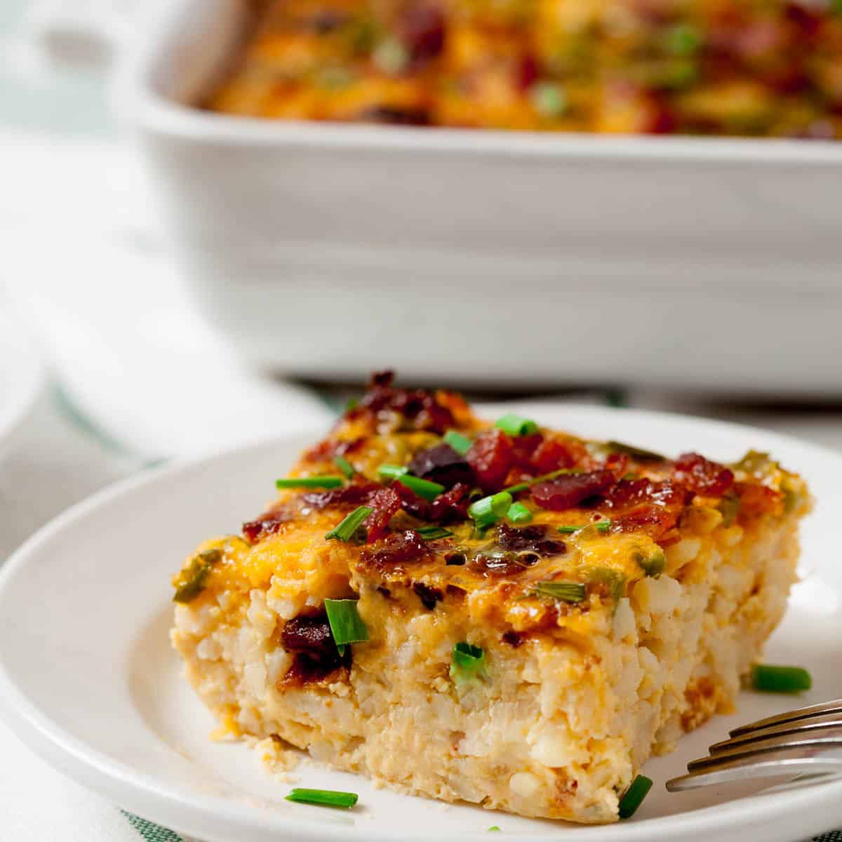 A piece of Bacon and Egg Casserole on a white plate.