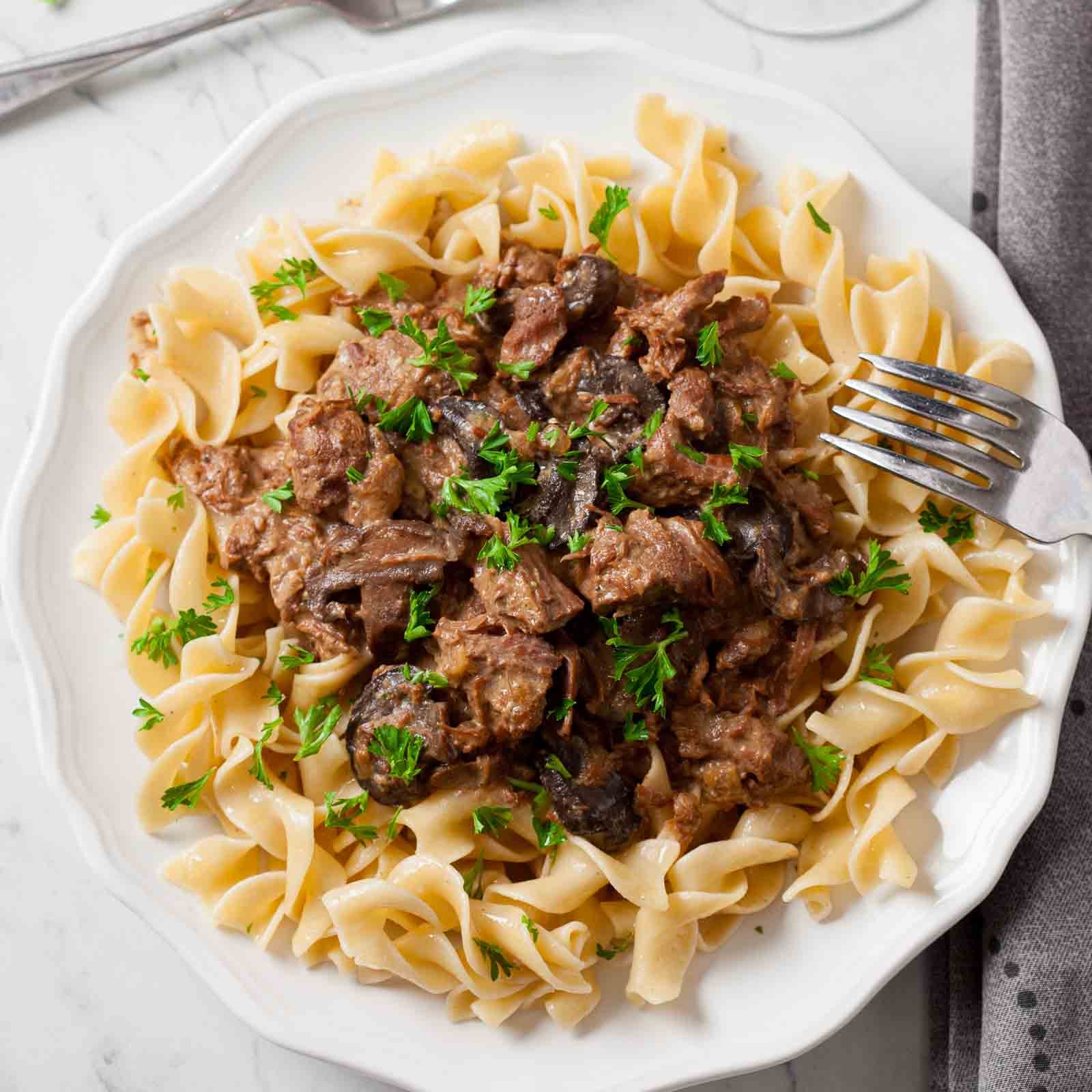 White plate full of slow cooker beef stroganoff.