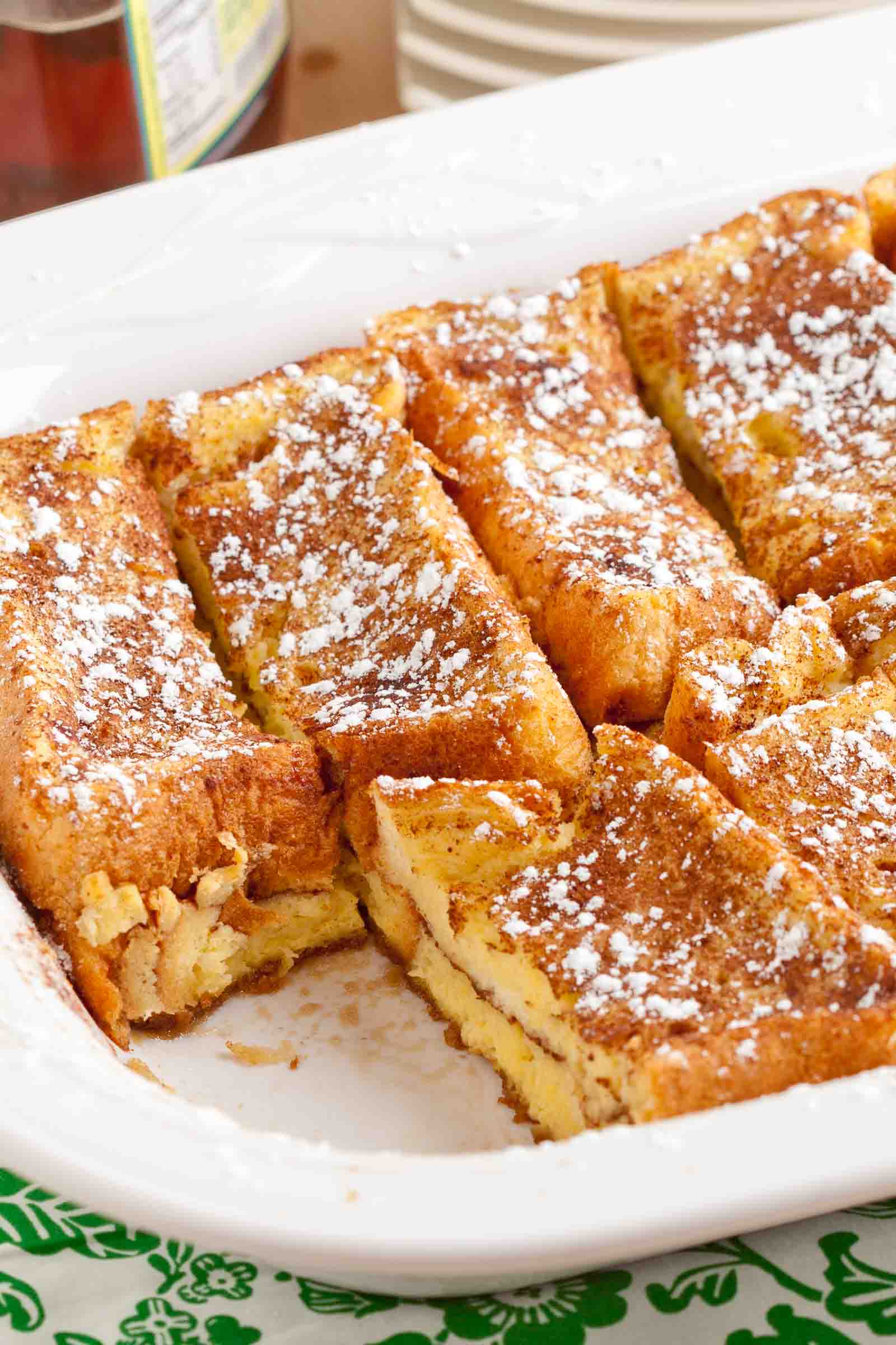 French Toast Bake using Texas Sliced bread that is fresh, with the casserole sliced up in a baking dish.