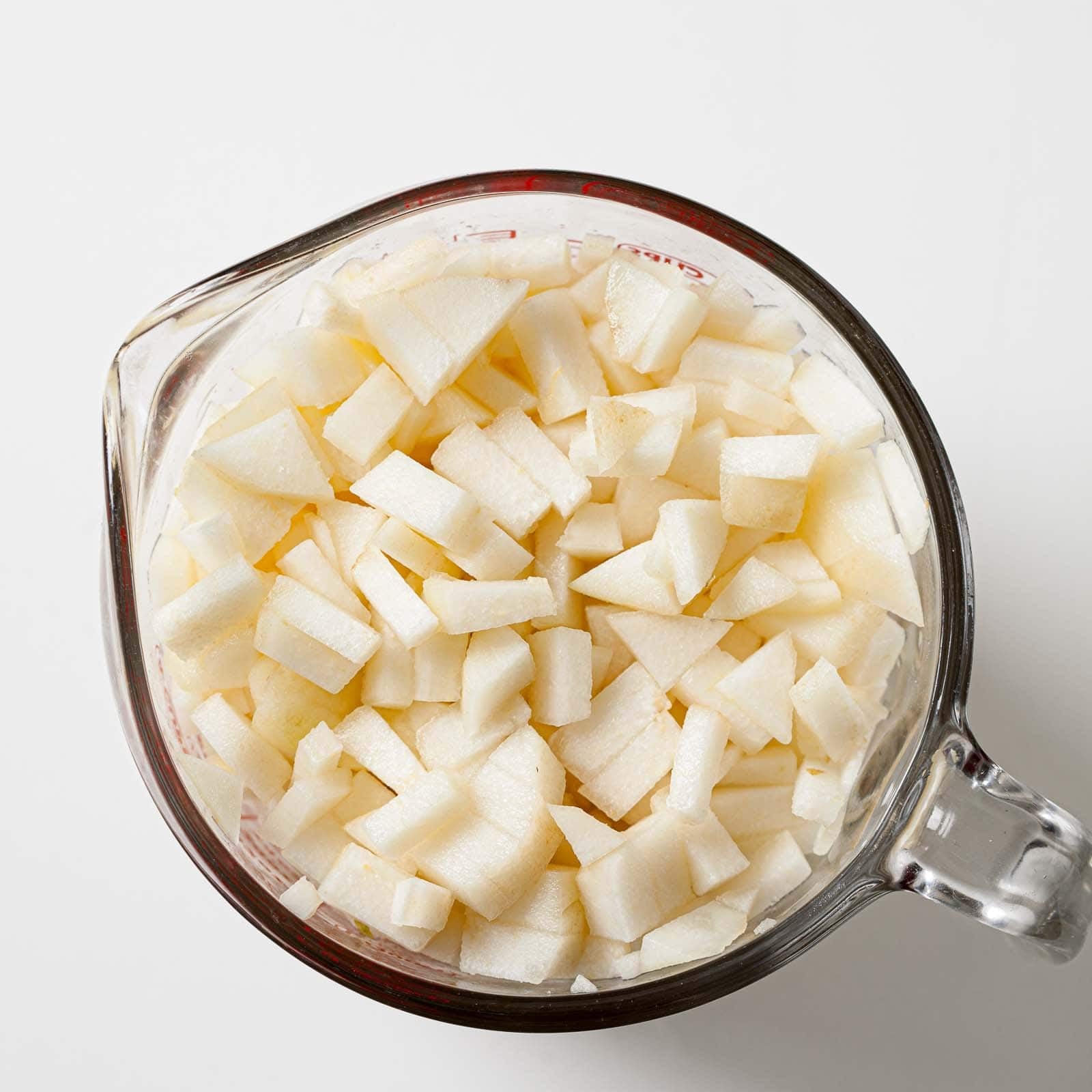 Diced pears in a measuring cup.