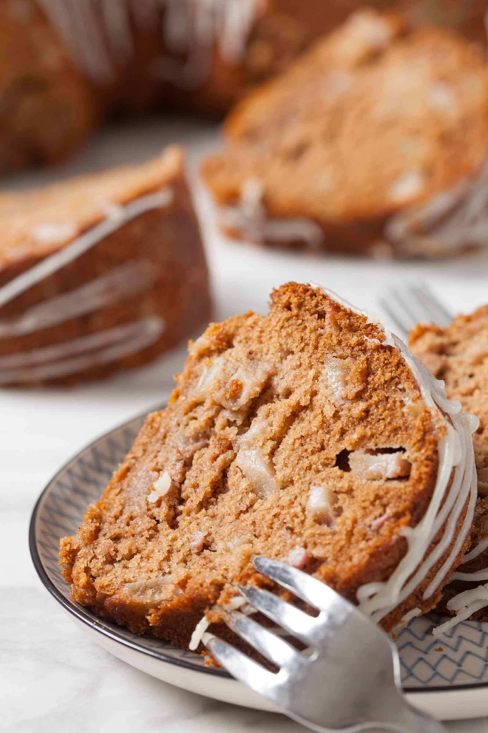 Slice of pear cake with a fork in it, getting ready to take a bite.
